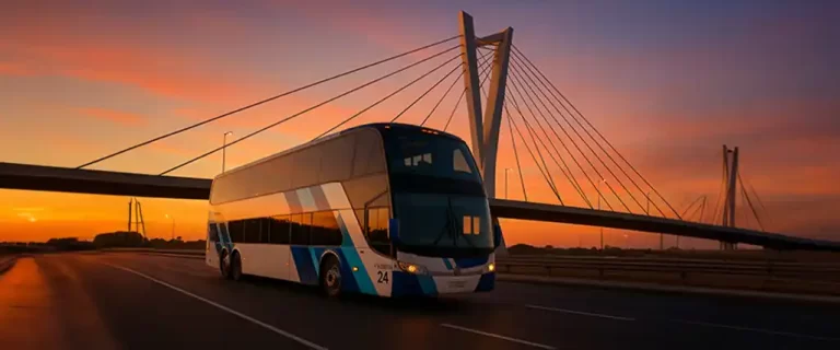 Ómnibus de dos pisos cruzando el Puente de las Américas en Montevideo al atardecer